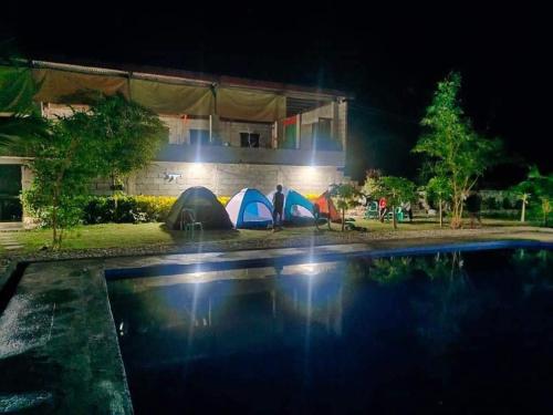 eine Gruppe von Zelten neben einem Pool in der Nacht in der Unterkunft Sevilleja's farm danglas abra in Bangued
