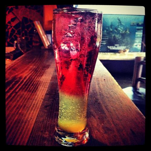 a drink in a glass sitting on a table at Jungle Monkey Backpackers in Port St Johns