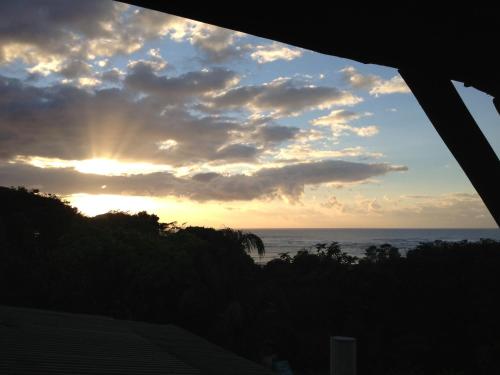 a sunset over the ocean with the sun in the sky at Jungle Monkey Backpackers in Port St Johns