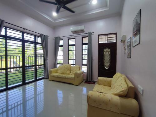 a living room with two chairs and a couch at NikNa Homestay Batu Rakit - WIFI in Kampong Ru Tujoh