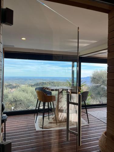 una sala da pranzo con un tavolo e una grande finestra di Villa & Spa Mas des Oliviers a Châteauneuf