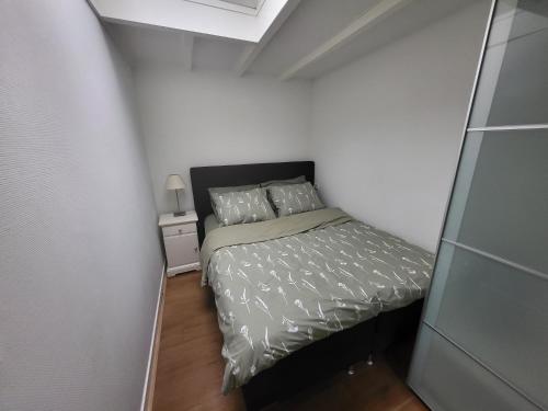 Habitación pequeña con cama y mesita de noche en Private Apartment., en Hilversum