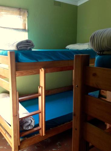 a bedroom with two bunk beds with blue sheets at Jungle Monkey Backpackers in Port St Johns