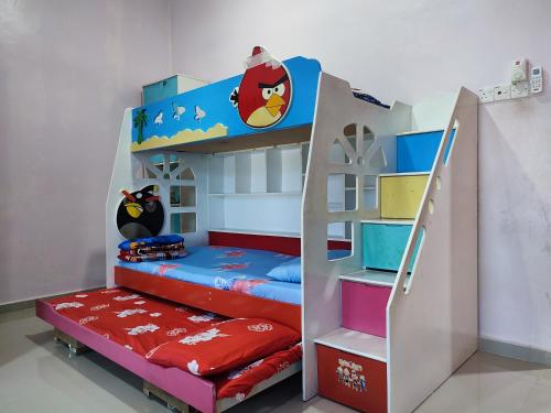 Ce lit superposé se trouve dans un dortoir doté d'une échelle et de lits superposés. dans l'établissement NikNa Homestay Batu Rakit - WIFI, à Kampong Ru Tujoh
