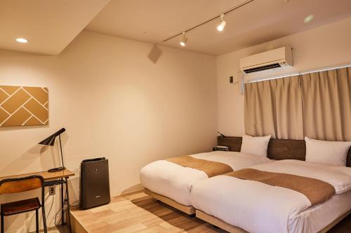 een slaapkamer met 2 bedden en een raam bij Riverside Arashiyama in Kyoto