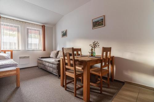 un soggiorno con tavolo, sedie e divano di Apartmán A5 pro 3 osoby - Monínec - celoročně a Moninec