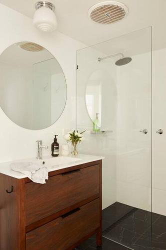 a bathroom with a sink and a mirror and a shower at Fuller Holidays - Get Sandy - Beachside Byron in Byron Bay