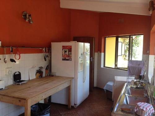a kitchen with a wooden counter and a white refrigerator at Jungle Monkey Backpackers in Port St Johns