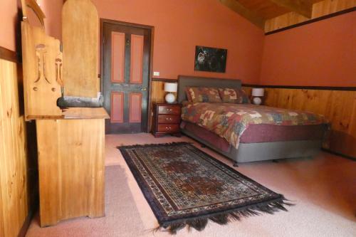 a bedroom with a bed and a rug and a door at Wrenwood Chalets in Augusta