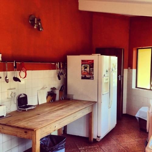 a kitchen with a wooden counter and a white refrigerator at Jungle Monkey Backpackers in Port St Johns