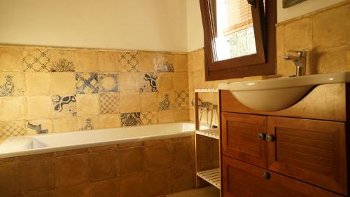 a bathroom with a bath tub and a sink at El Higuerón (Serranía de Ronda) in Jimera de Líbar