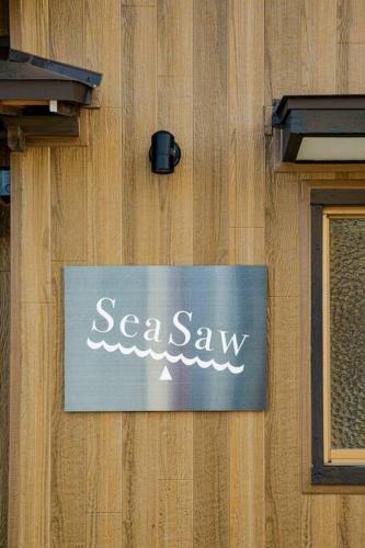 a sign on the side of a building with a seawax sign at Sea Saw in Isumi