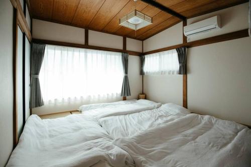 a large white bed in a room with a window at Sea Saw in Isumi