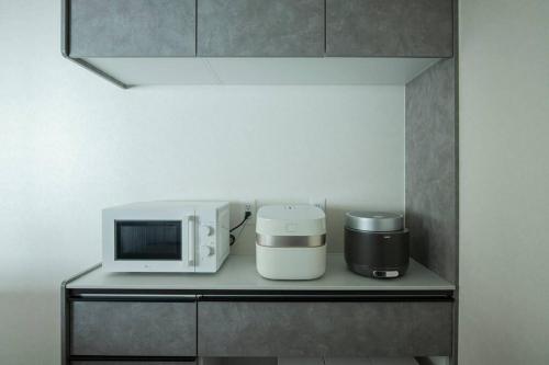 a microwave and a coffee maker on a shelf at Sea Saw in Isumi