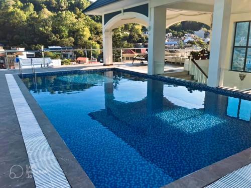 una piscina de agua azul en una casa en Lynh's Villa en Cat Ba