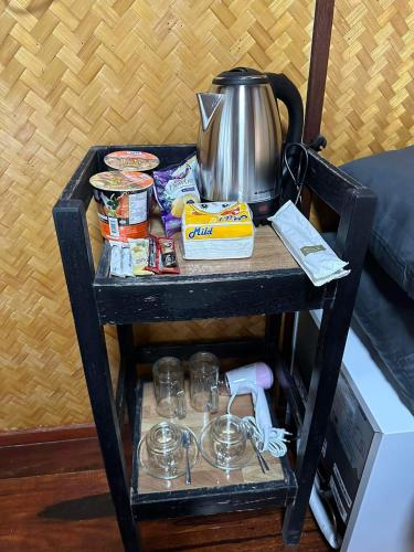 a black cart with a tea kettle on top of it at ปลายเขื่อนแคมป์ปิ้ง บ้านเรือไทย in Sirindhorn