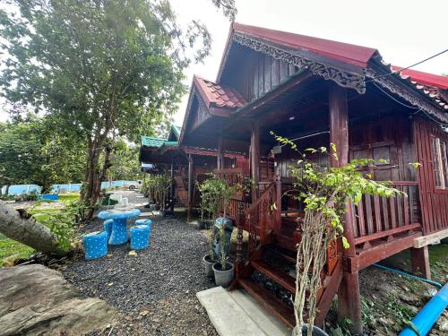 a small house with blue pots in front of it at ปลายเขื่อนแคมป์ปิ้ง บ้านเรือไทย in Sirindhorn