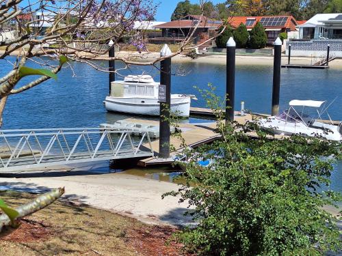 a boat is docked at a dock on the water at Supa sized 3 bedroom 2 bath in Gold Coast