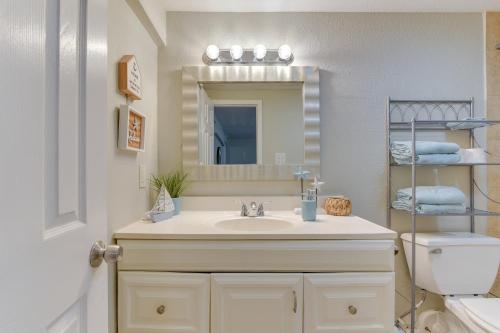 a bathroom with a sink and a mirror and a toilet at Walk to Beach Cozy Unit in Galveston! in Galveston
