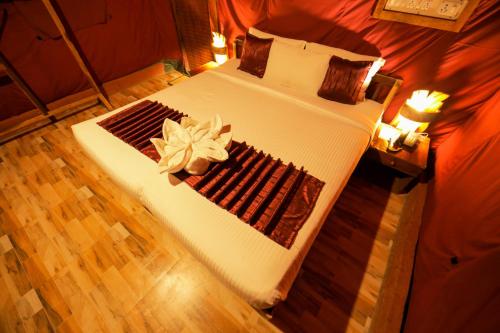 a bedroom with a large bed with a flower on it at Nature Zone Jungle Resort in Munnar