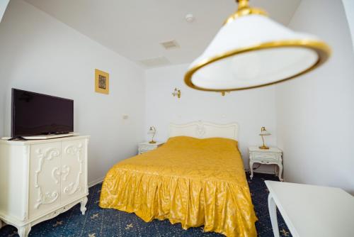 1 dormitorio con 1 cama, TV y lámpara de araña en Complex Vața Băi, en Vaţa de Jos