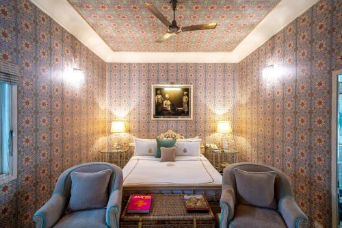 a bedroom with a bed and two chairs at Rajmahal Palace RAAS in Jaipur