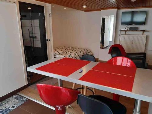 een kamer met een rode tafel en stoelen bij Studio 1 à 4 pers, proche Strasbourg, Europa-Park, Colmar in Erstein