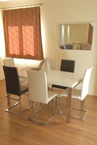 a white dining room table with chairs and a mirror at Lilian Apartments in Budva