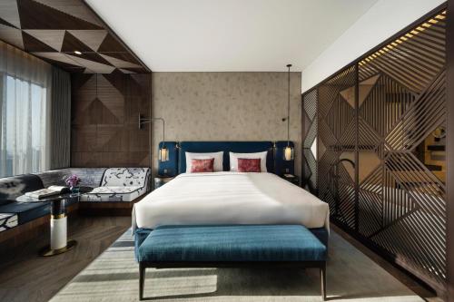 a bedroom with a large bed and a couch at SO/ Uptown Dubai in Dubai