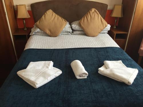 a bed with towels and pillows on it at Welbeck Hotel - Close to Beach, Train Station & Southend Airport in Southend-on-Sea