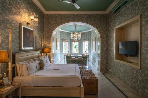 a bedroom with a bed and a television in it at Rajmahal Palace RAAS in Jaipur