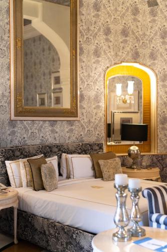 a bedroom with a bed with a mirror and a table at Rajmahal Palace RAAS in Jaipur