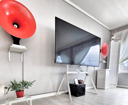 a flat screen tv on a wall with a red balloon at Aewol Torini in Jeju