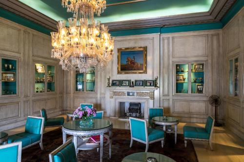 a dining room with a chandelier and a table and chairs at Rajmahal Palace RAAS in Jaipur