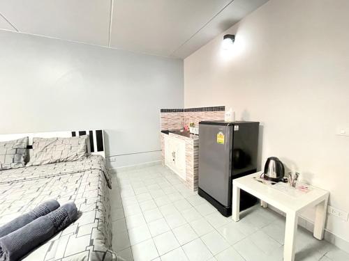 um quarto com uma cama, uma mesa e um frigorífico em Impact Arena C3 Milo em Nonthaburi