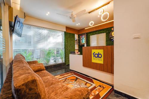 FabHotel Happy Home Stays في بانغالور: غرفة معيشة مع أريكة وتلفزيون