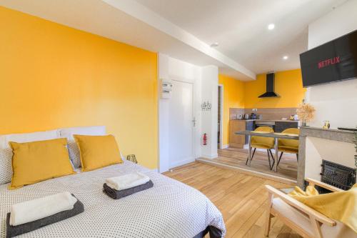 Cet appartement comprend une chambre avec un lit aux murs jaunes et une cuisine. dans l'établissement CASALOVA07, à Serrières