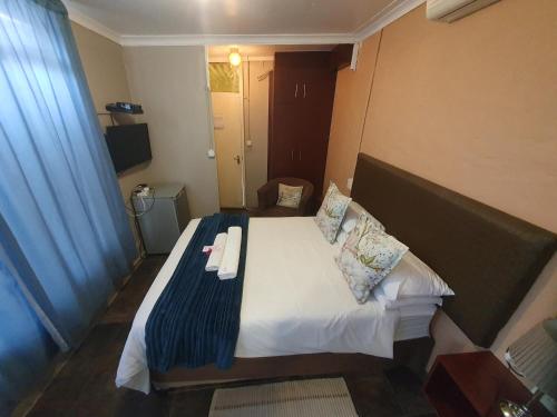 a hotel room with a bed with a blue blanket at Lavender Lane in Ladysmith