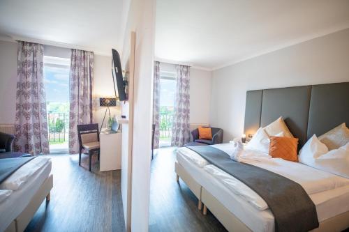 a hotel room with a bed and a large window at Hotel Marc Aurel in Petronell