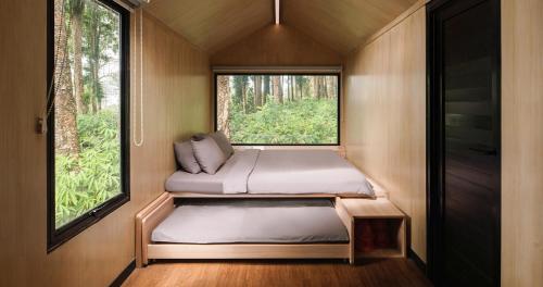 2 camas en una habitación pequeña con ventana en Bobocabin Baturraden, Purwokerto, en Tenjo