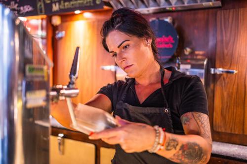 a woman in a kitchen using her cell phone at Hotel Marc Aurel in Petronell
