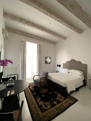 a bedroom with a bed and a chair and a table at Casa Calamondino in Bari