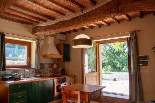 蘇比亞諾的住宿－Alloro, accogliente monolocale a Val di Nima, Arezzo，厨房配有桌子和大窗户
