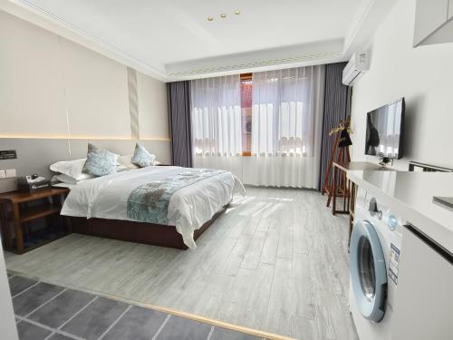 una camera d'albergo con letto e TV di Zhangjiajie Porui Hotel - Tianmen Mountain a Zhangjiajie
