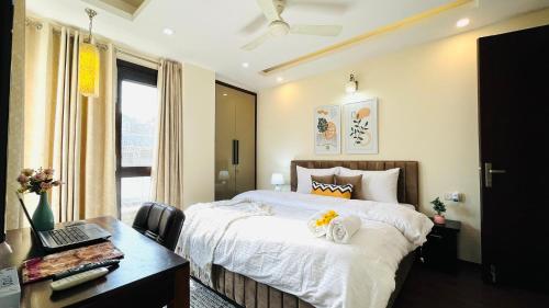 a bedroom with a bed and a desk with a laptop at Olive Serviced Apartments - Defence Colony in New Delhi