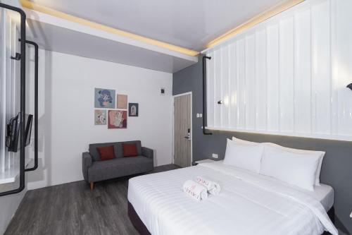 a bedroom with a large white bed and a chair at Istanaku in Manado