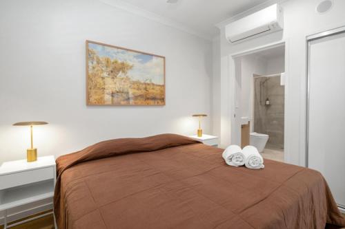 Un dormitorio con una cama con dos zapatos blancos. en Lake Poco Apartments, en Mackay