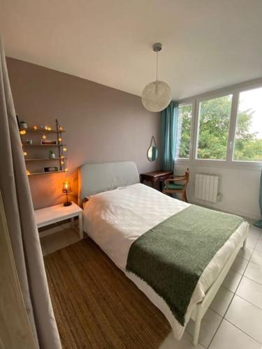 - une chambre avec un lit, une table et une fenêtre dans l'établissement Charmant appartement quartier école d’agronomie, à Montpellier