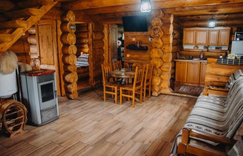 a kitchen and dining room in a log cabin at Cabana La Matei in Suceava