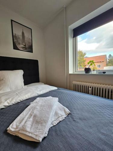 um quarto com uma cama com um cobertor em Lejlighed med altan og gratis parkering em Aalborg